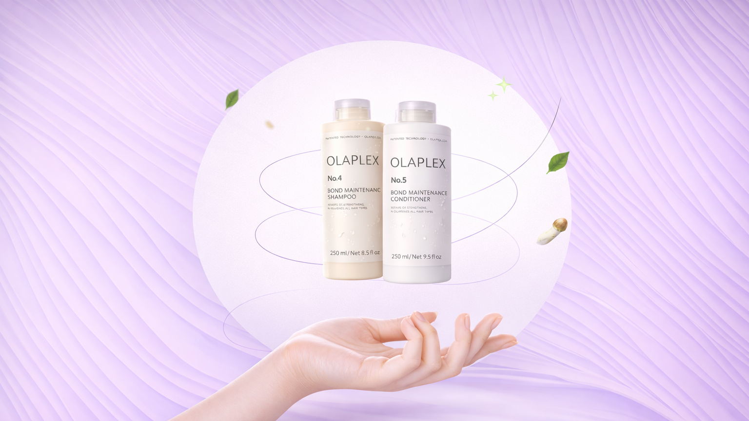 Two bottles of Olaplex hair care products held by a hand against a purple background